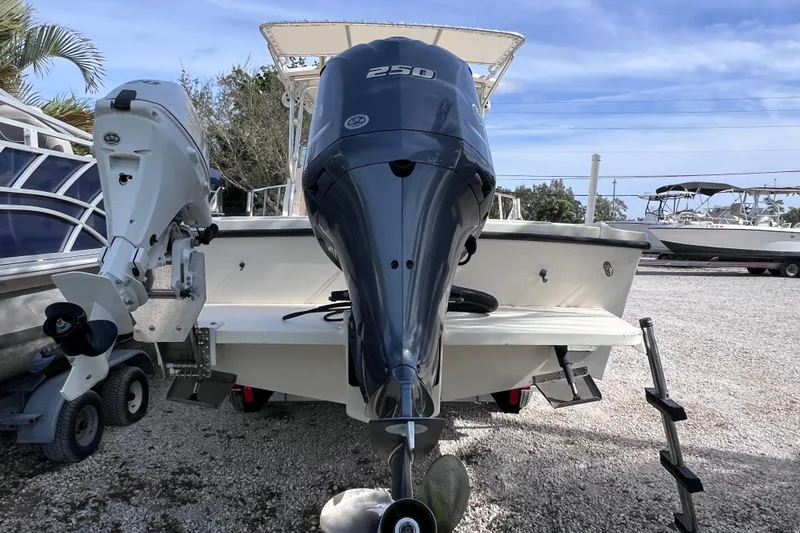 Slide: The Image of 2005 Parker 2510 Walkaround boat with dual outboard motors on a gravel lot. - 10