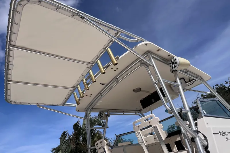 Slide: The Image of 2005 Parker 2510 Walkaround boat with T-top and rod holders under a clear blue sky. - 12