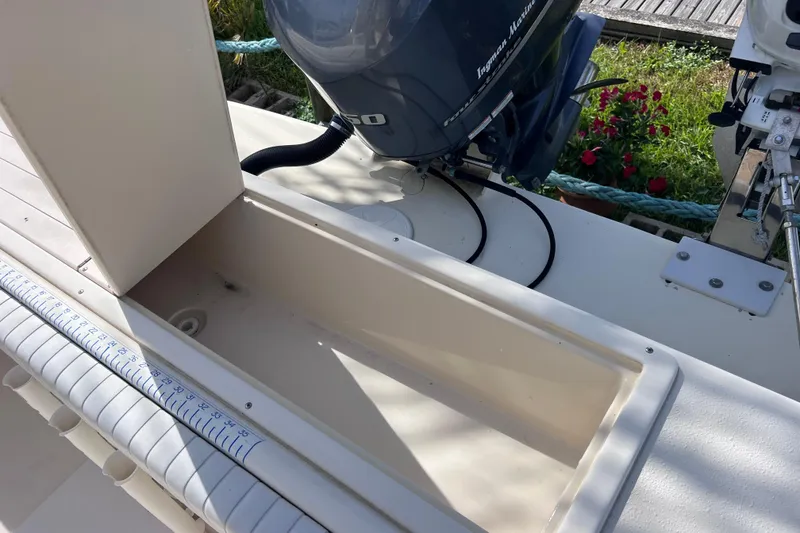 Slide: The Image of 2005 Parker 2510 Walkaround boat with open storage compartment and visible outboard motor. - 19