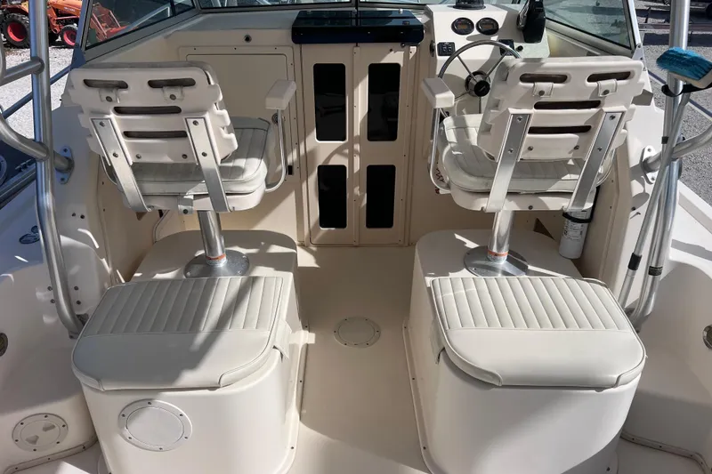 Slide: The Image of 2005 Parker 2510 Walkaround boat interior with dual captain chairs and control panel. - 20