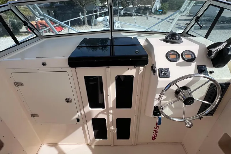 Slide: The Image of 2005 Parker 2510 Walkaround boat dashboard with steering wheel and gauges. - 25