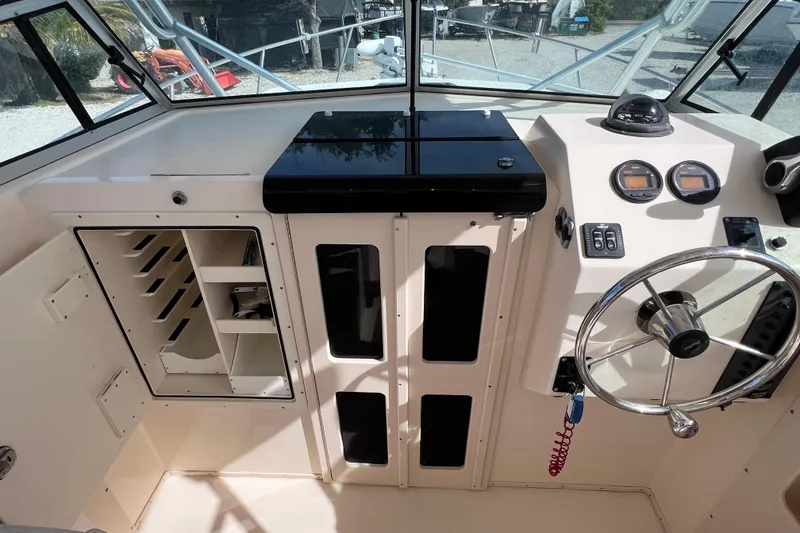 Slide: The Image of 2005 Parker 2510 Walkaround boat interior with steering wheel and control panel. - 26