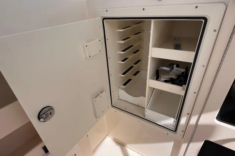 Slide: The Image of Open storage compartment in 2005 Parker 2510 Walkaround boat, featuring shelves and organized space. - 27