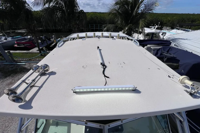 Slide: The Image of 2005 Parker 2510 Walkaround boat roof with mounted equipment and palm trees in background. - 42