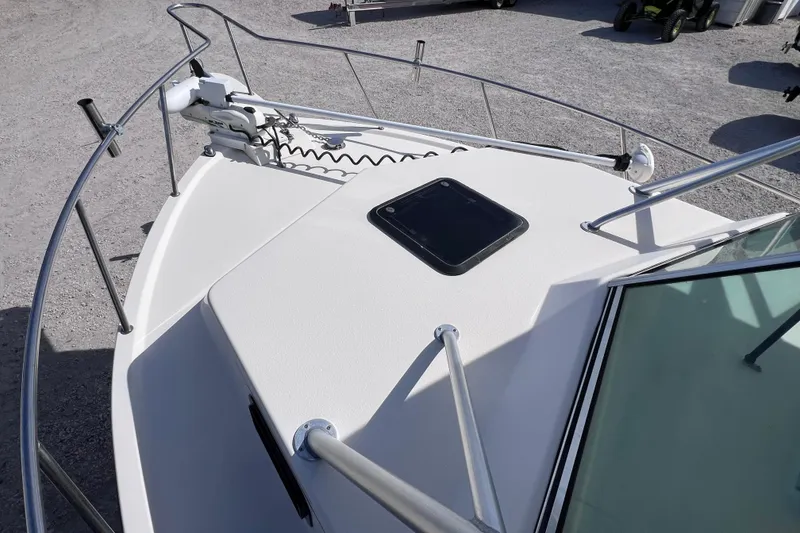 Slide: The Image of 2005 Parker 2510 Walkaround boat deck with railing and hatch, parked on gravel. - 43