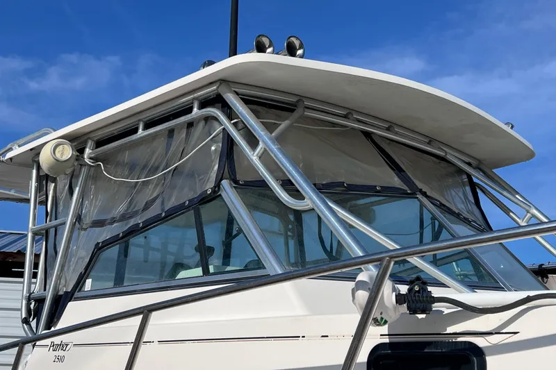 Slide: The Image of 2005 Parker 2510 Walkaround boat with metal frame and clear canopy under blue sky. - 57