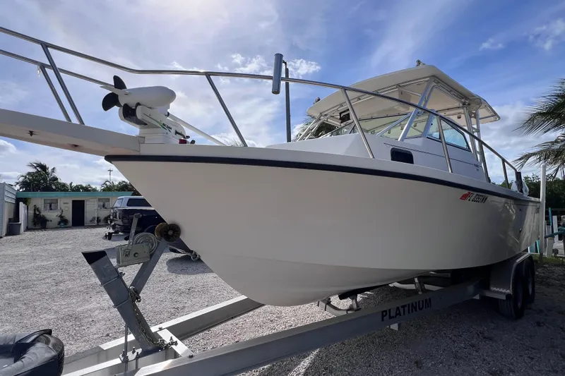 Slide: The Image of 2005 Parker 2510 Walkaround boat on trailer, parked outdoors under a clear sky. - 6