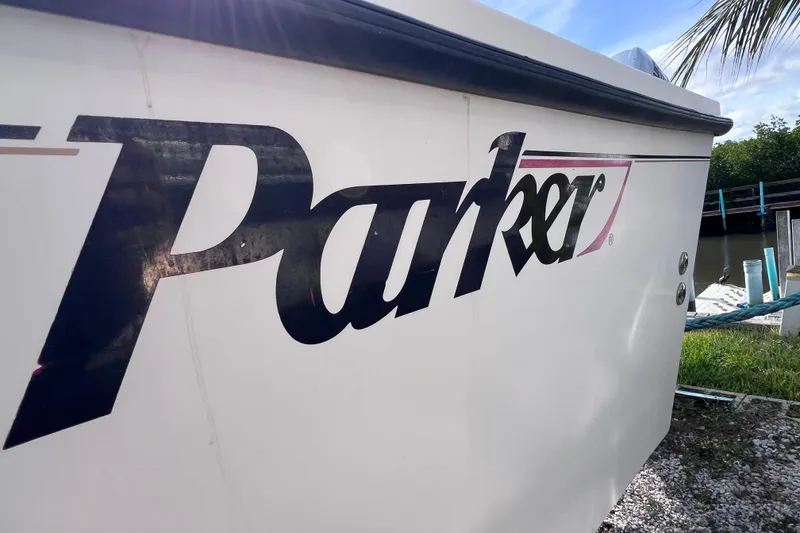 Slide: The Image of Side view of 2005 Parker 2510 Walkaround boat with logo, docked near water. - 8