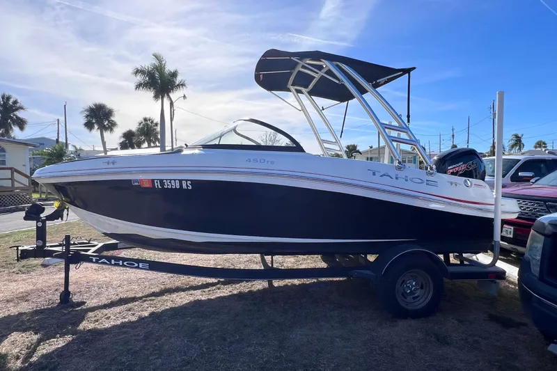 Slide: The Image of 2019 Tahoe 450 TS boat on trailer, parked outdoors under clear sky. - 1