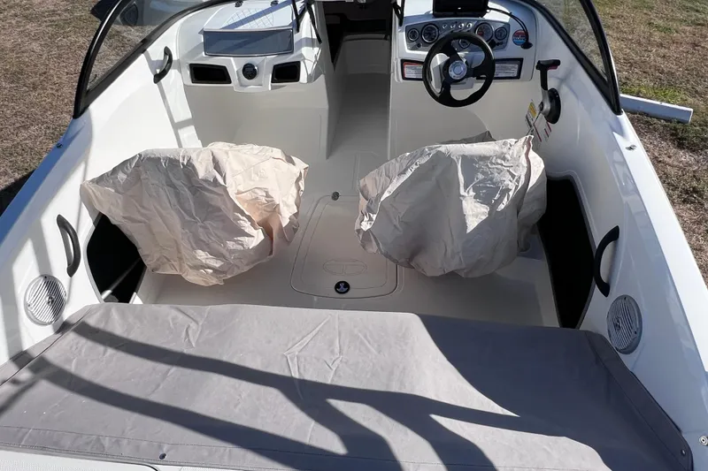 Slide: The Image of 2019 Tahoe 450 TS boat interior with covered seats and steering wheel. - 12