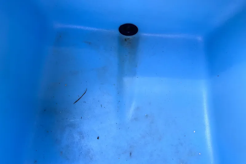 Slide: The Image of Blue interior of a 2019 Tahoe 450 TS boat with drain plug. - 18