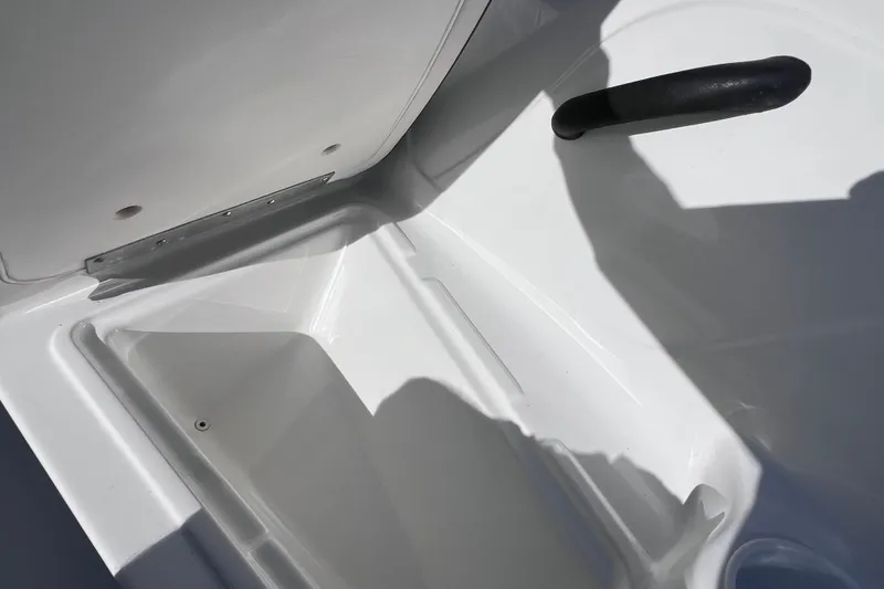 Slide: The Image of Open storage compartment in a 2019 Tahoe 450 TS boat, featuring a sleek white interior. - 27