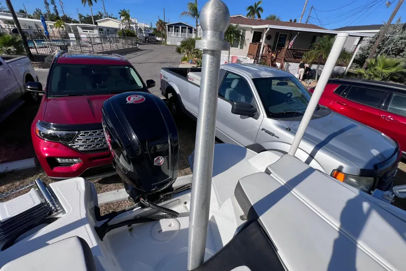 Slide: The Image of 2019 Tahoe 450 TS boat with Mercury outboard motor, parked near red and silver vehicles. - 30