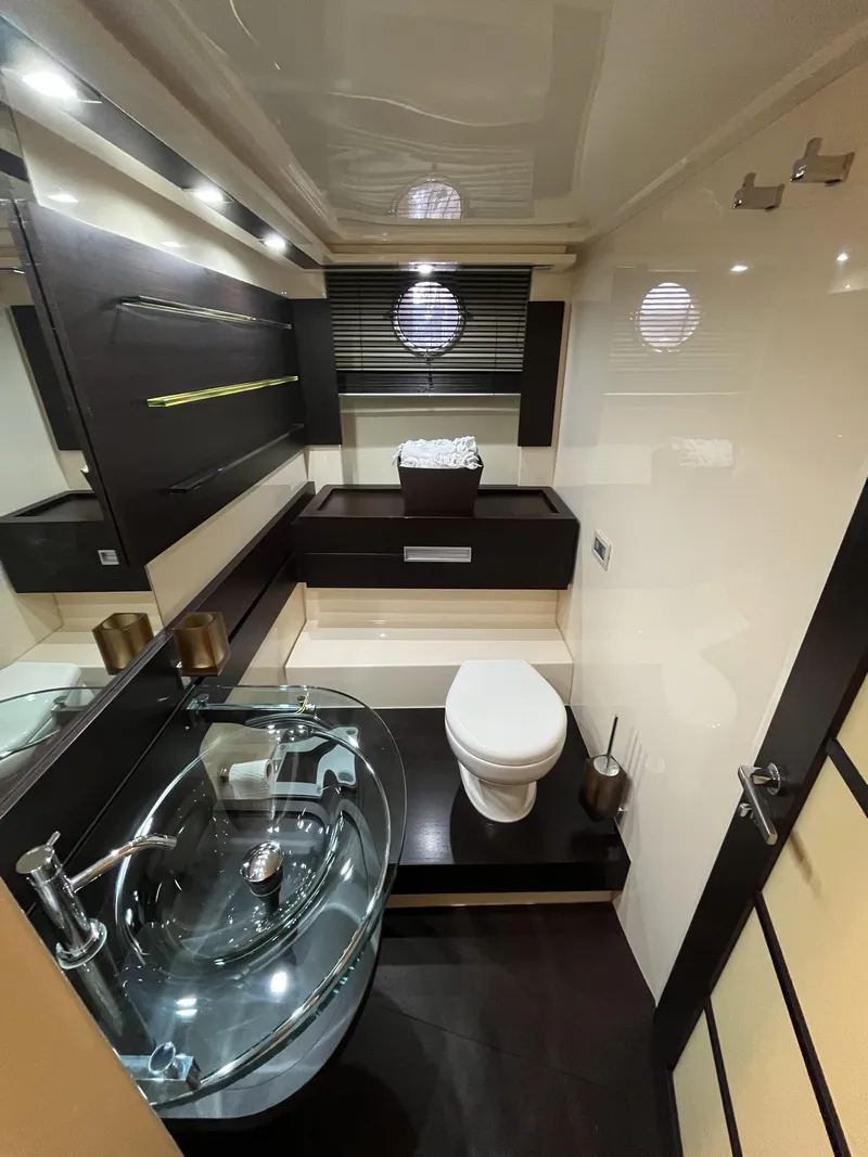 Slide: The Image of Luxurious bathroom in a 2008 Azimut 62S yacht with modern fixtures and glass sink. - 31
