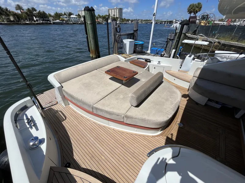 Slide: The Image of 2008 Azimut 62S yacht deck with cushioned seating and wooden flooring, docked by the water. - 8