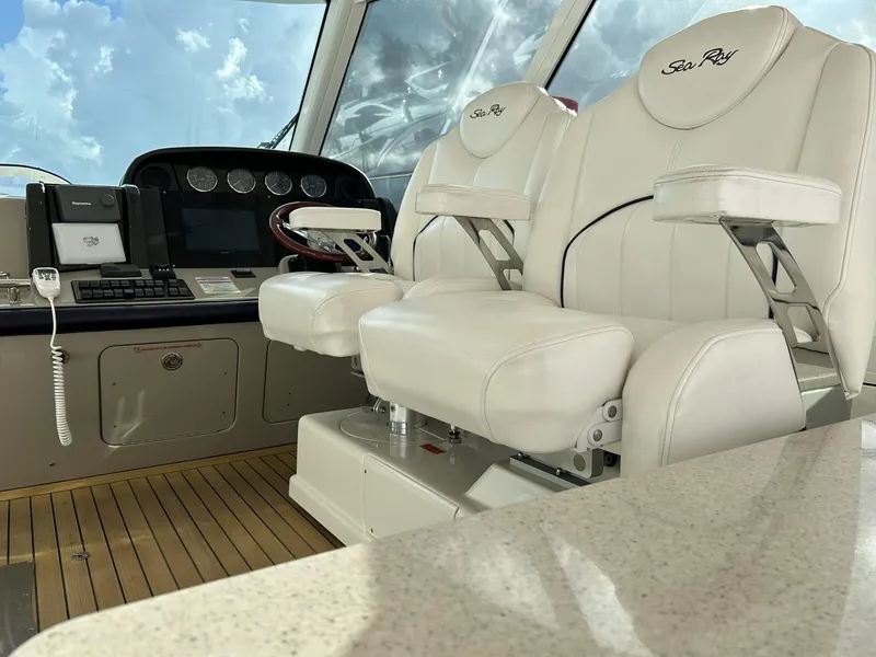 Slide: The Image of 2008 Sea Ray 480 Sundancer helm with white leather seats and control panel. - 10