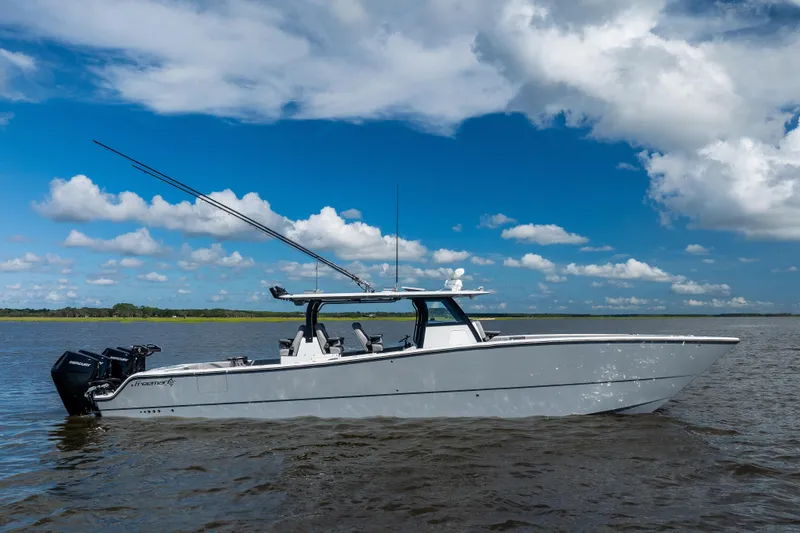 Slide: The Image of 2023 Freeman 47 boat on calm water under a blue sky with clouds. - 1