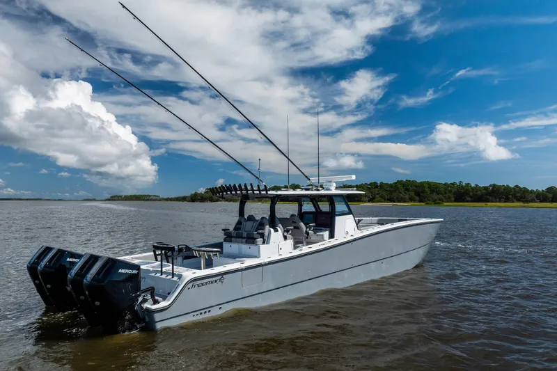 Slide: The Image of 2023 Freeman 47 boat on water, featuring dual Mercury engines under a clear blue sky. - 16
