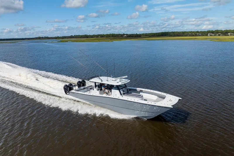 Slide: The Image of 2023 Freeman 47 boat cruising on a scenic waterway under a blue sky. - 26