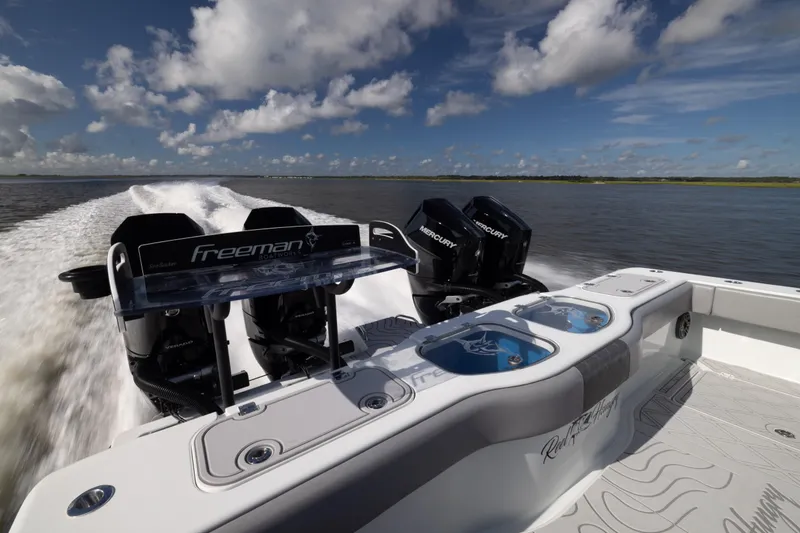 Slide: The Image of 2023 Freeman 47 boat with dual Mercury engines cruising on open water. - 35