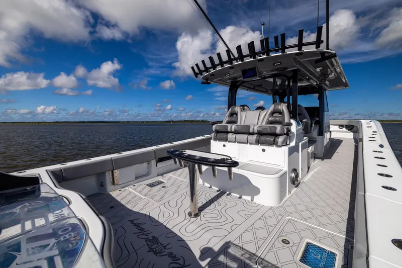 Slide: The Image of 2023 Freeman 47 boat interior with seating, rod holders, and open deck under a blue sky. - 42
