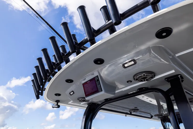 Slide: The Image of 2023 Freeman 47 boat roof with rod holders and electronic equipment against blue sky. - 49