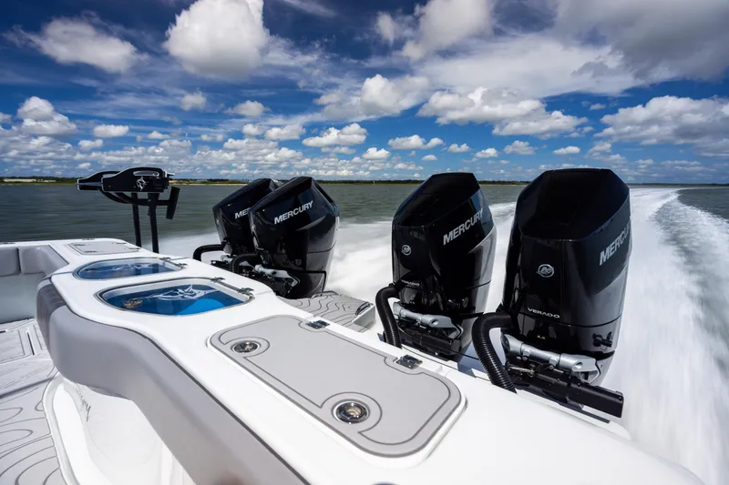 Slide: The Image of 2023 Freeman 47 boat with Mercury engines cruising on open water under a blue sky. - 51