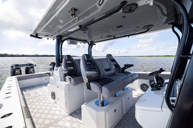 Slide: The Image of 2023 Freeman 47 boat interior with luxurious seating and modern controls on a calm water backdrop. - 58