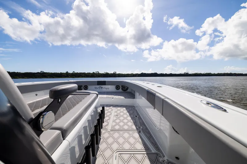 Slide: The Image of 2023 Freeman 47 boat interior with seating, under a bright blue sky and clouds. - 76