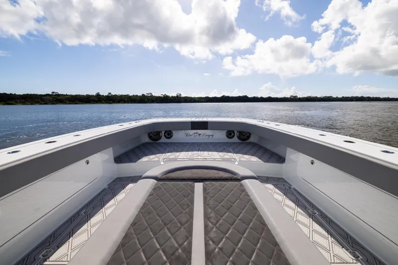 Slide: The Image of 2023 Freeman 47 boat interior with quilted seating, overlooking serene water and sky. - 77