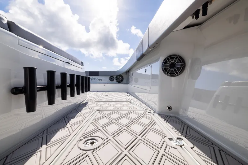 Slide: The Image of 2023 Freeman 47 boat interior with rod holders and speakers under a bright sky. - 78