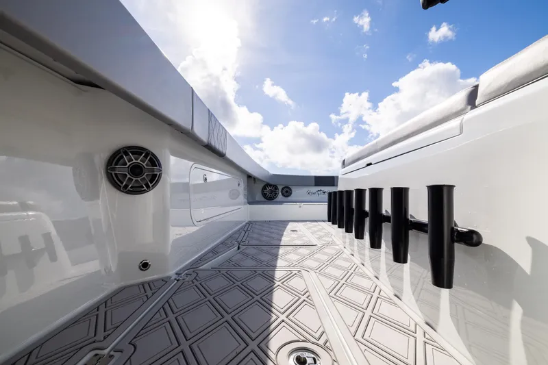 Slide: The Image of 2023 Freeman 47 boat interior with rod holders and speakers under a bright sky. - 79