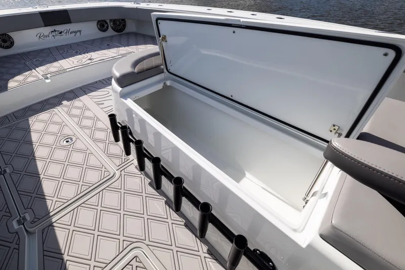 Slide: The Image of 2023 Freeman 47 boat with open storage compartment and rod holders on deck. - 81