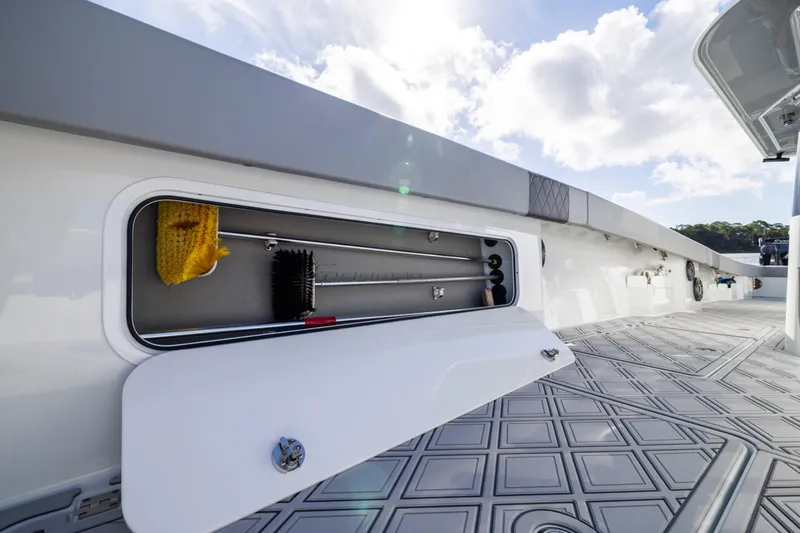 Slide: The Image of Storage compartment on 2023 Freeman 47 boat deck, featuring cleaning tools and accessories. - 82