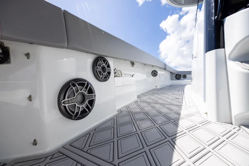 Slide: The Image of 2023 Freeman 47 boat deck with speakers and patterned flooring under a blue sky. - 97