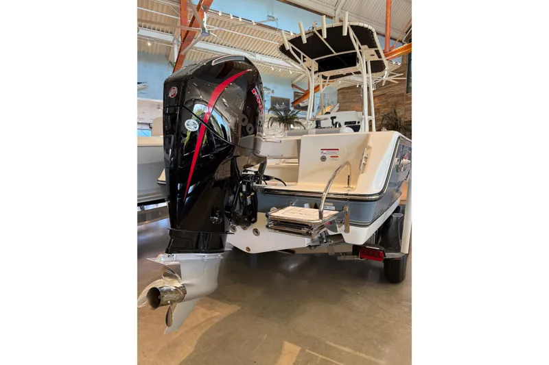 Slide: The Image of 2026 Mako 214 Center Console boat with powerful outboard motor in showroom. - 6