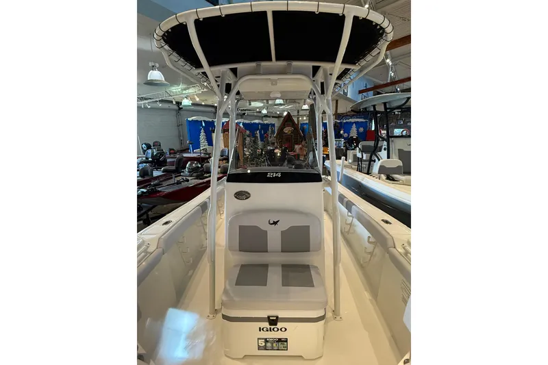 Slide: The Image of 2026 Mako 214 Center Console boat with T-top and Igloo cooler in showroom. - 9