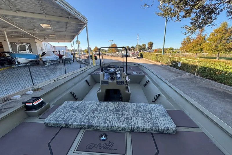 Slide: The Image of 2026 Tracker Grizzly 2072 CC boat at a dealership, showcasing interior and console. - 2