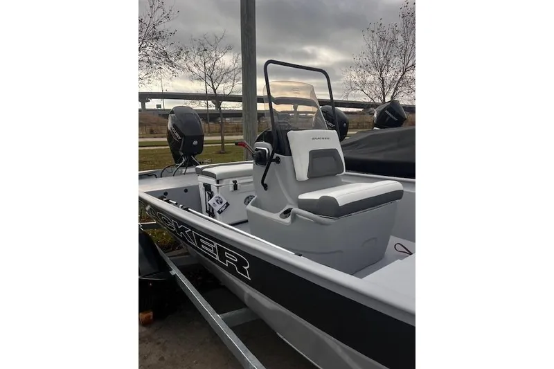 Slide: The Image of 2026 Tracker Bass Tracker Classic CC boat with console and seating, parked outdoors. - 51