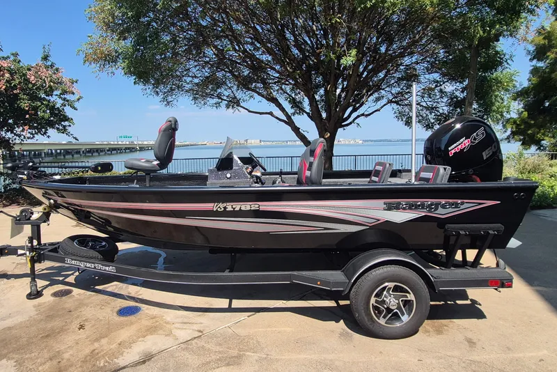 The Image of 2026 Ranger VS1782SC Reata boat on trailer by waterfront, under tree. - 0