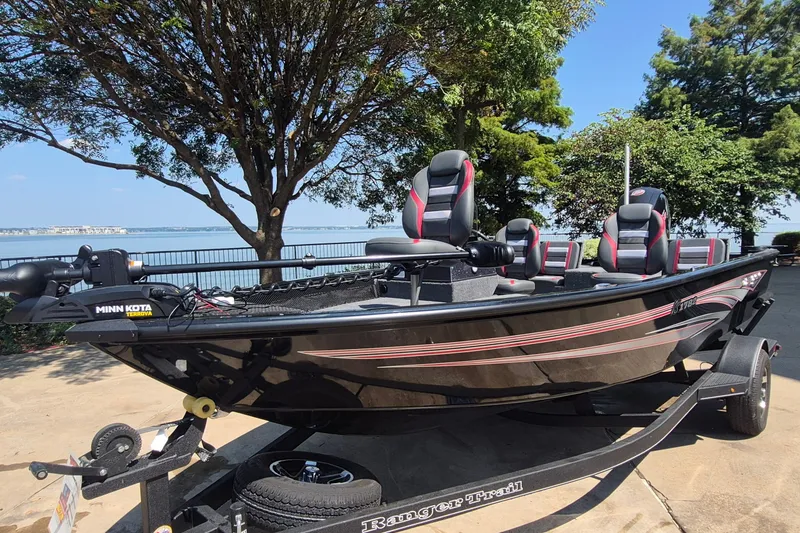Slide: The Image of 2026 Ranger VS1782SC Reata boat on trailer by lakeside, featuring Minn Kota motor. - 1