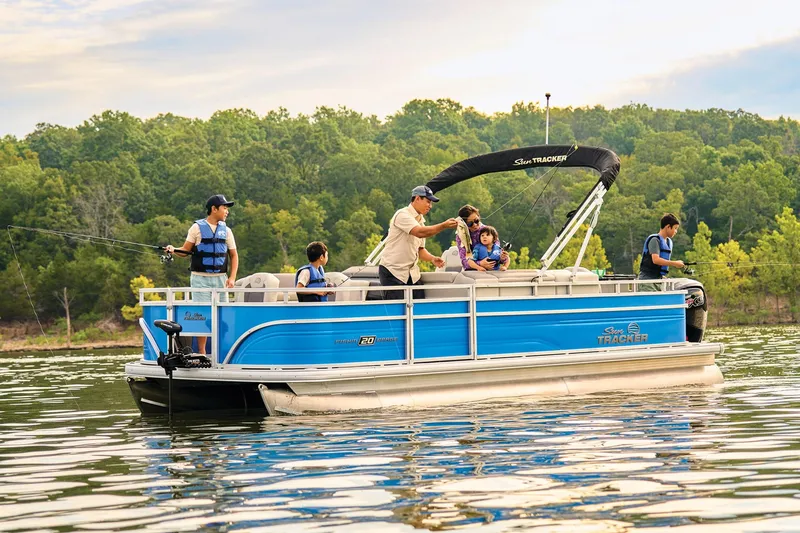 Slide: The Image of 2026 Sun Tracker Fishin' Barge 20 DLX interior with seating and blue paneling. - 10