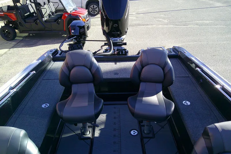 Slide: The Image of 2026 Nitro ZV21 Pro boat interior with dual seats and motor, parked outdoors. - 5