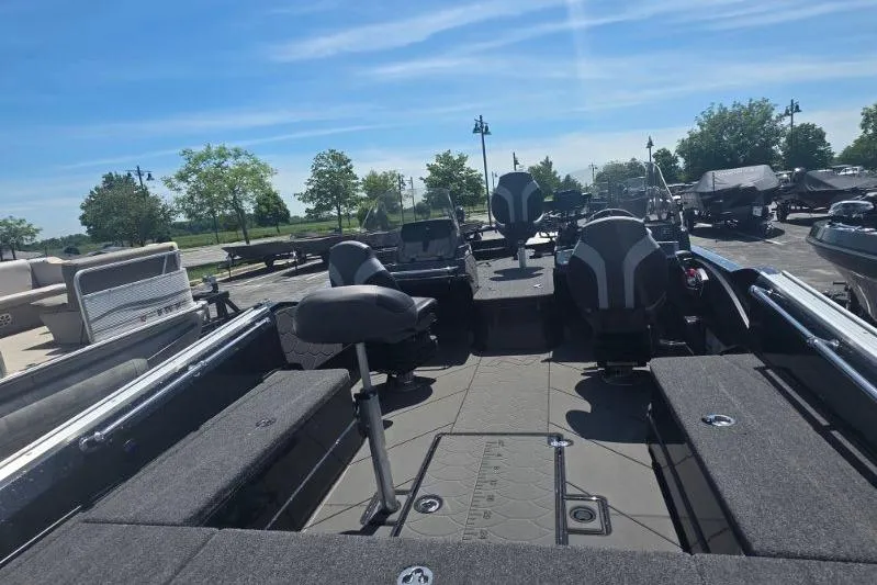 Slide: The Image of 2026 Nitro ZV21 boat interior with seating and storage, parked outdoors under a clear sky. - 26