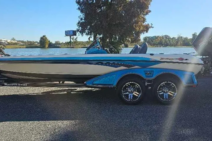 The Image of 2026 Ranger Z521 boat by a lake, featuring sleek design and vibrant blue accents. - 0