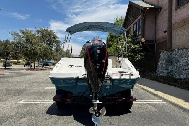 Slide: The Image of 2026 Tahoe 1950 boat with outboard motor parked outdoors. - 3