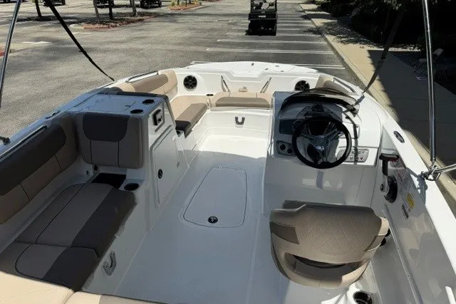 Slide: The Image of 2026 Tahoe 1950 boat interior with beige seating and modern steering wheel in a parking lot. - 6