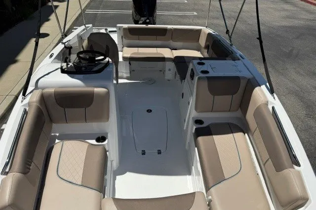 Slide: The Image of 2026 Tahoe 1950 boat interior with beige seating and steering console. - 9