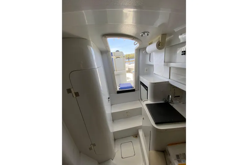 Slide: The Image of Interior of 1996 Intrepid 337 boat, featuring compact kitchen and storage area. - 12