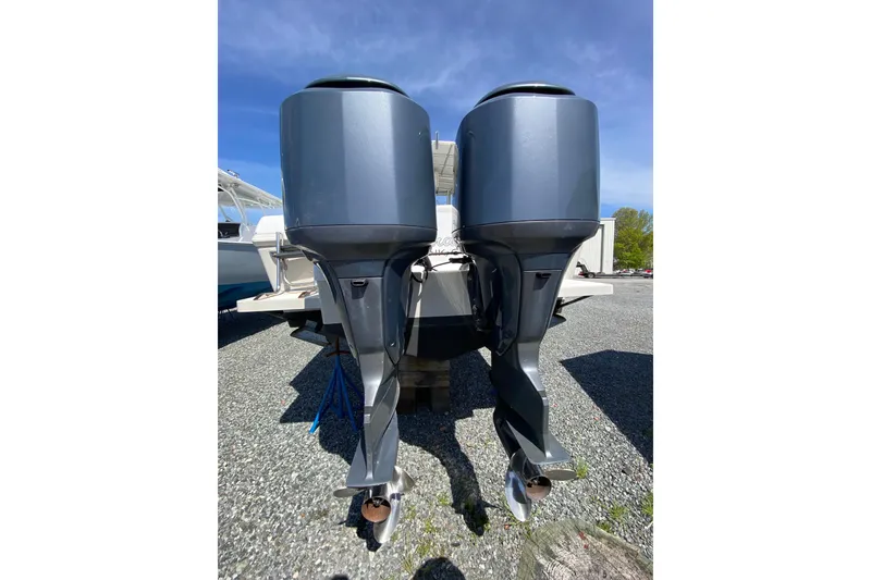 Slide: The Image of Twin outboard motors on a 1996 Intrepid 337 boat, parked on gravel. - 16
